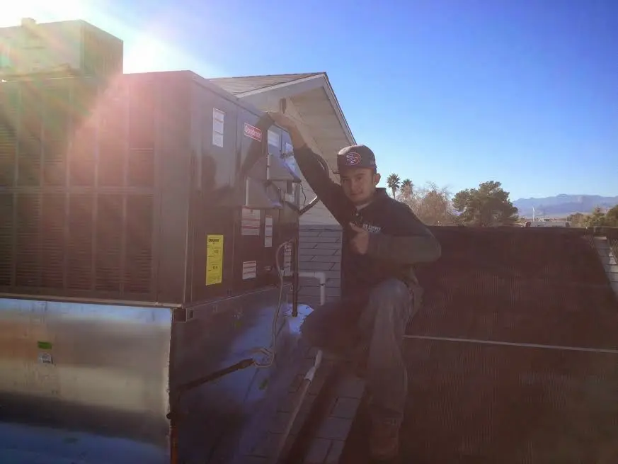 HVAC technician performing Heat Pump Repair on a rooftop unit in Portage